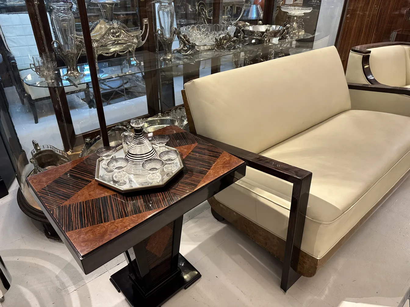 Antique small table with elegant design and geometric shapes, surrounded by glassware.