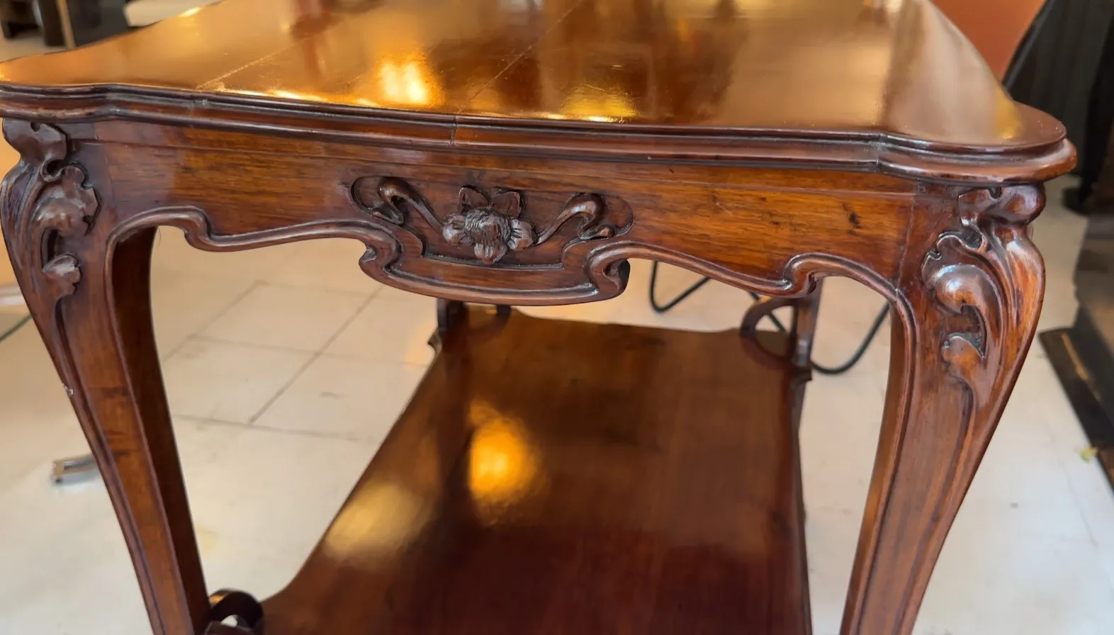 antique small table with intricate leg carvings, warm setting