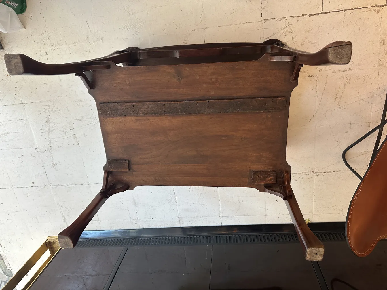 Antique small table with decorative legs, minimalist environment.