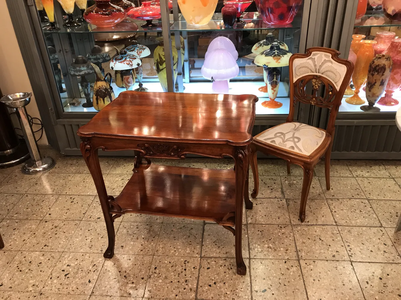 Antique small table with elegant curved design, surrounded by decorative items.