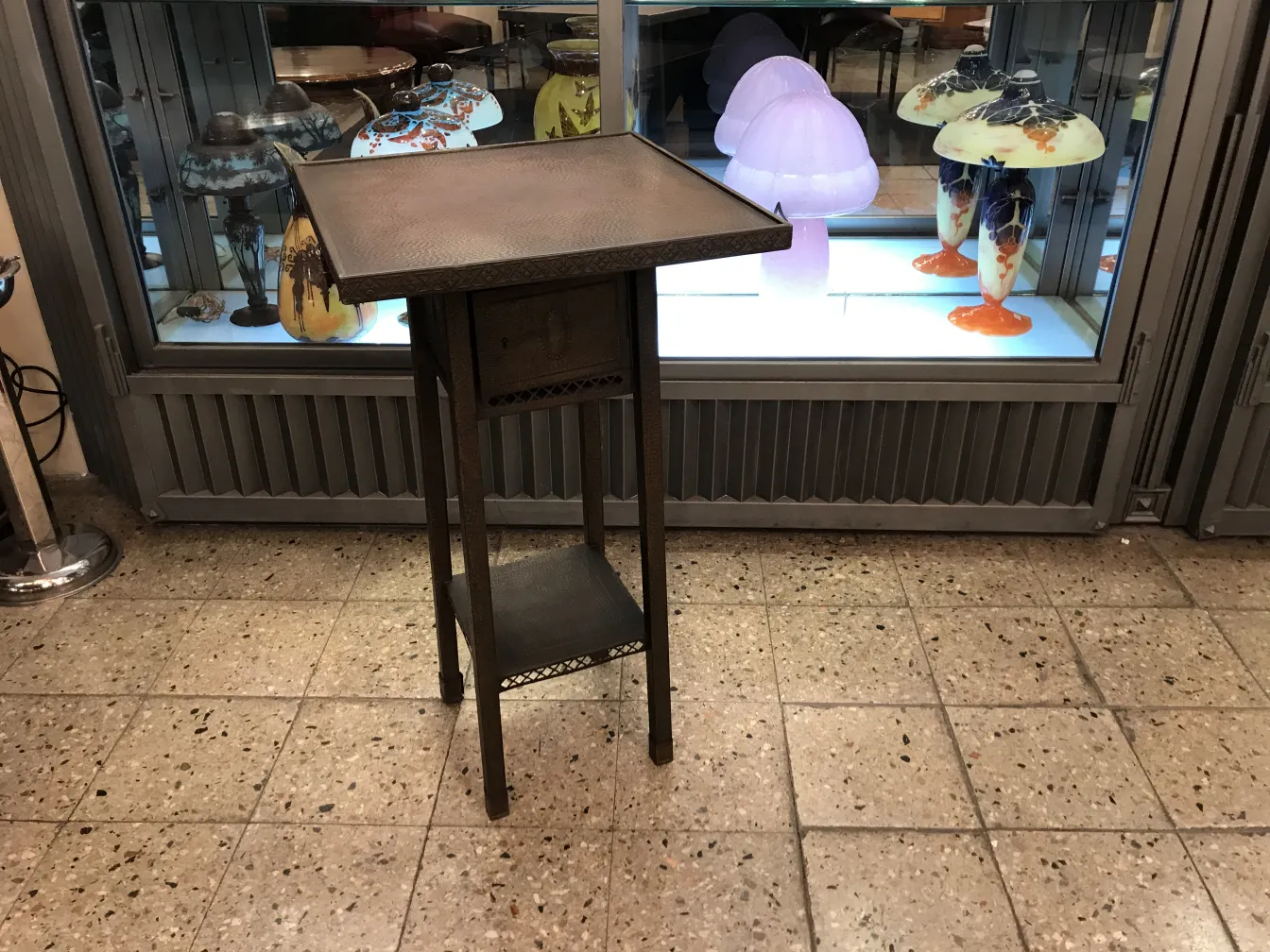 antique small table with unique design, surrounded by decorative lamps
