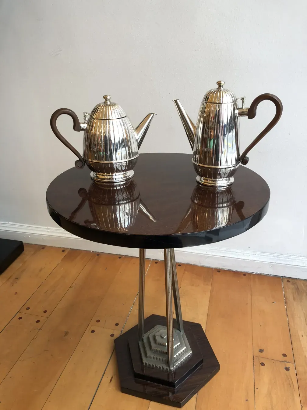 antique round small table with two shiny coffee pots