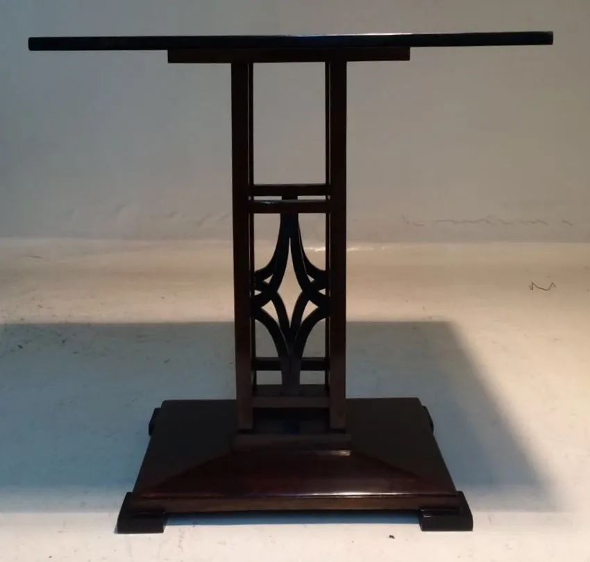 Antique small table with stylized design, simple environment.