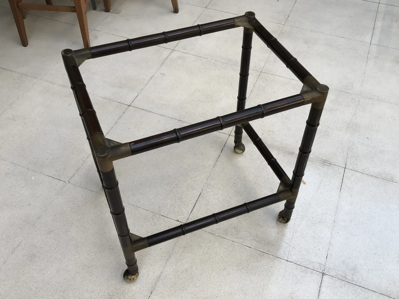 Small antique table with thin legs and delicate structure, in a bright setting.