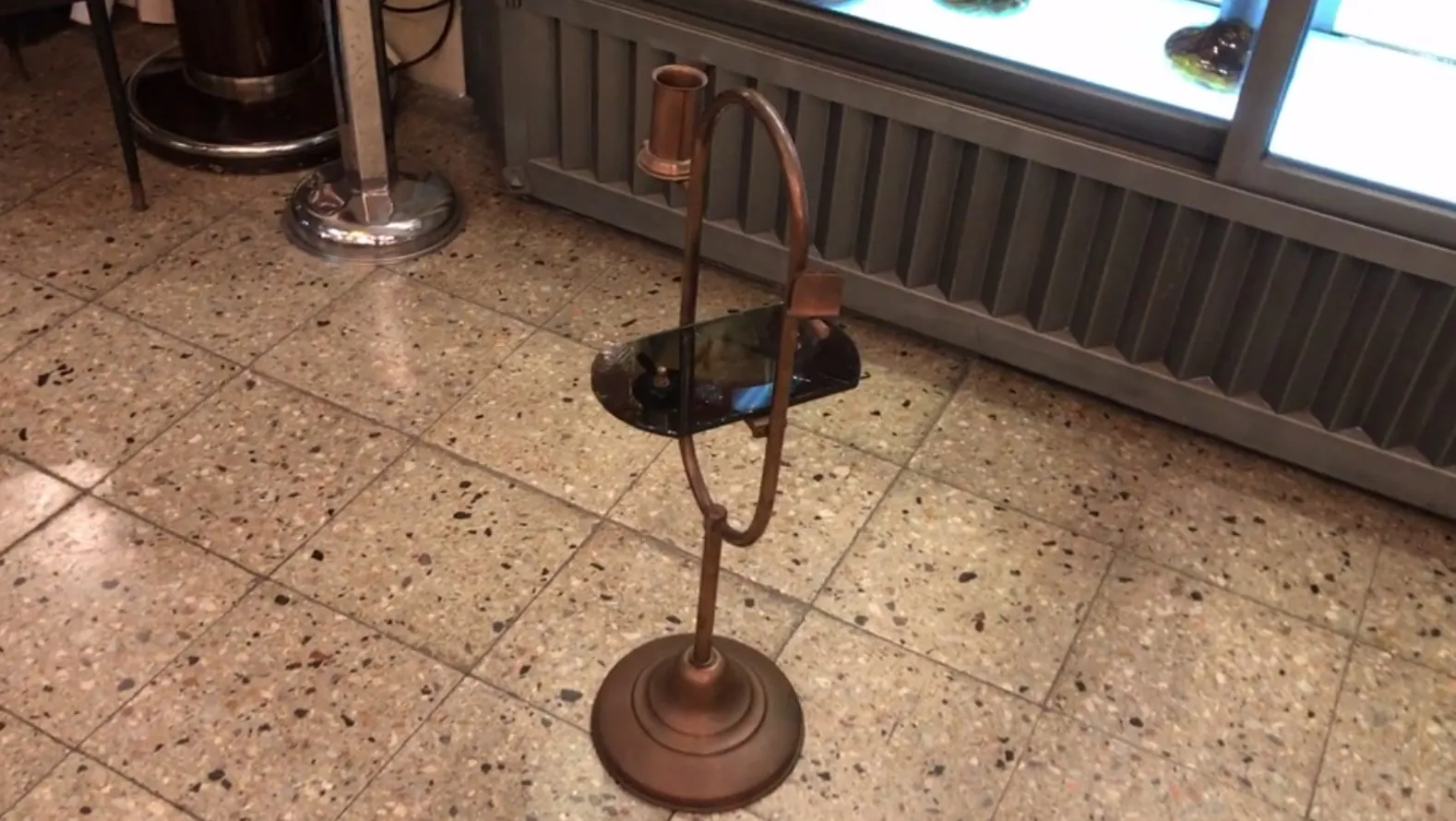 antique small table with black top and round base, in a cozy setting