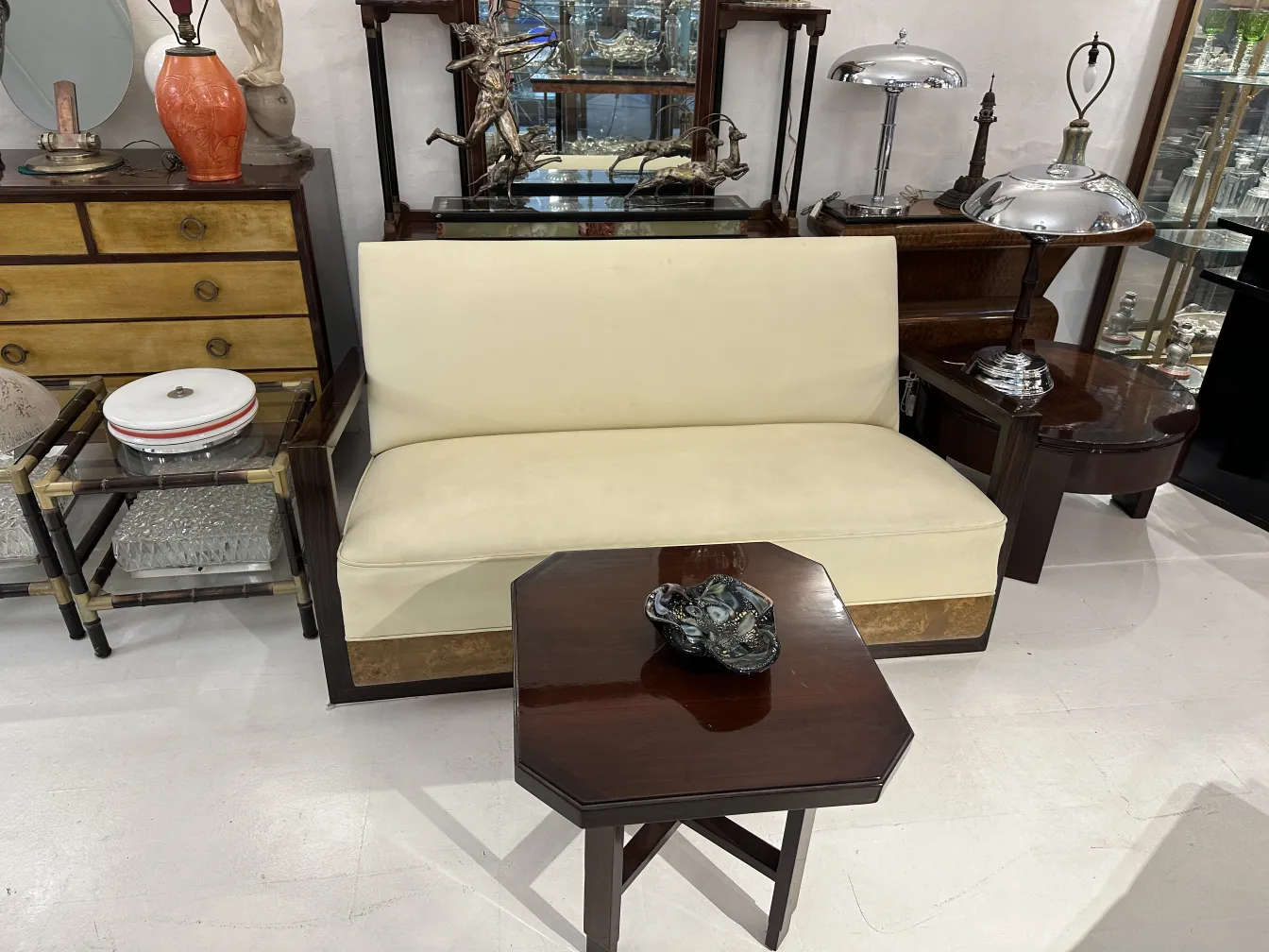 Antique small table with an octagonal shape, decorated, in an environment with other antiques.