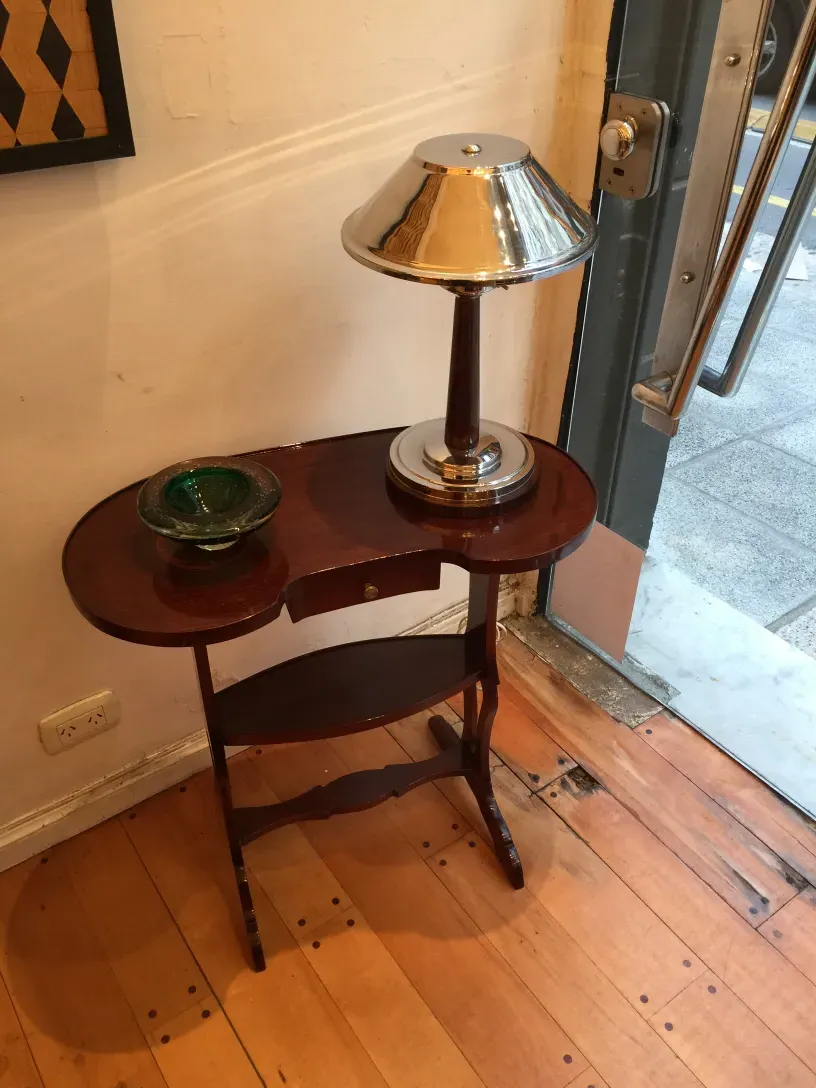 antique small table with a lamp and a decorative plate on top