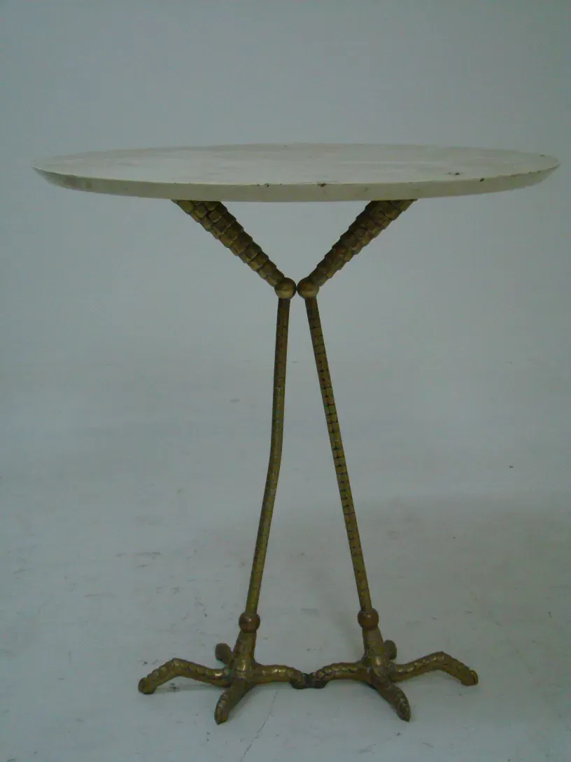 antique table with serpent-shaped legs and round surface