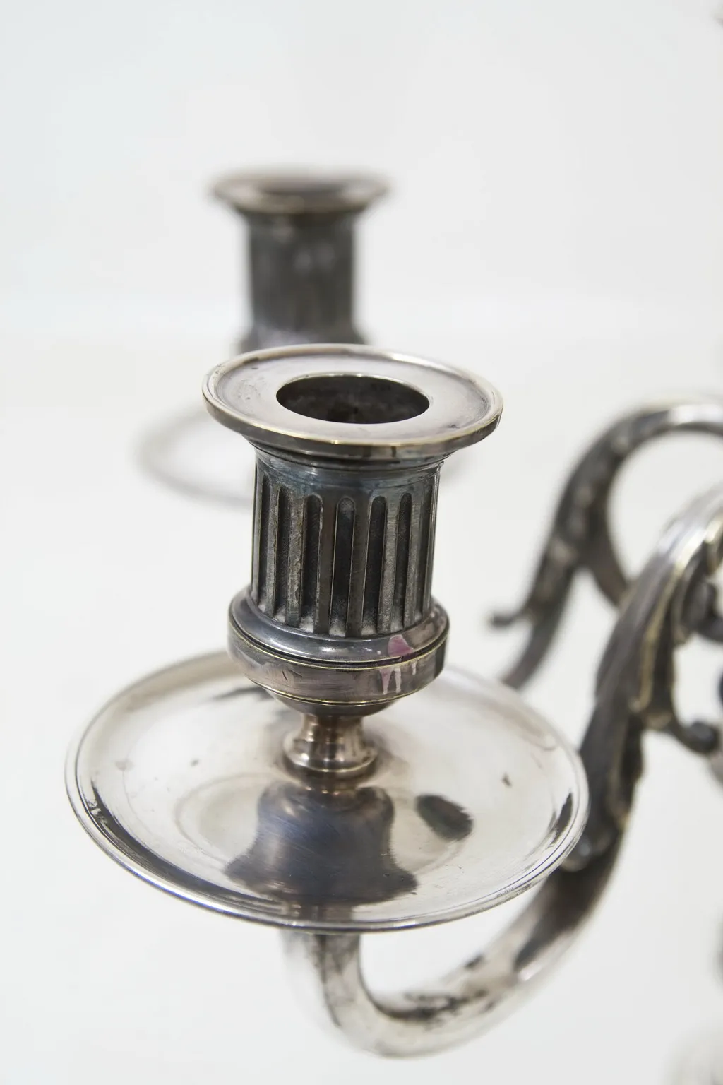 Two antique candelabras with classic design in an elegant setting.