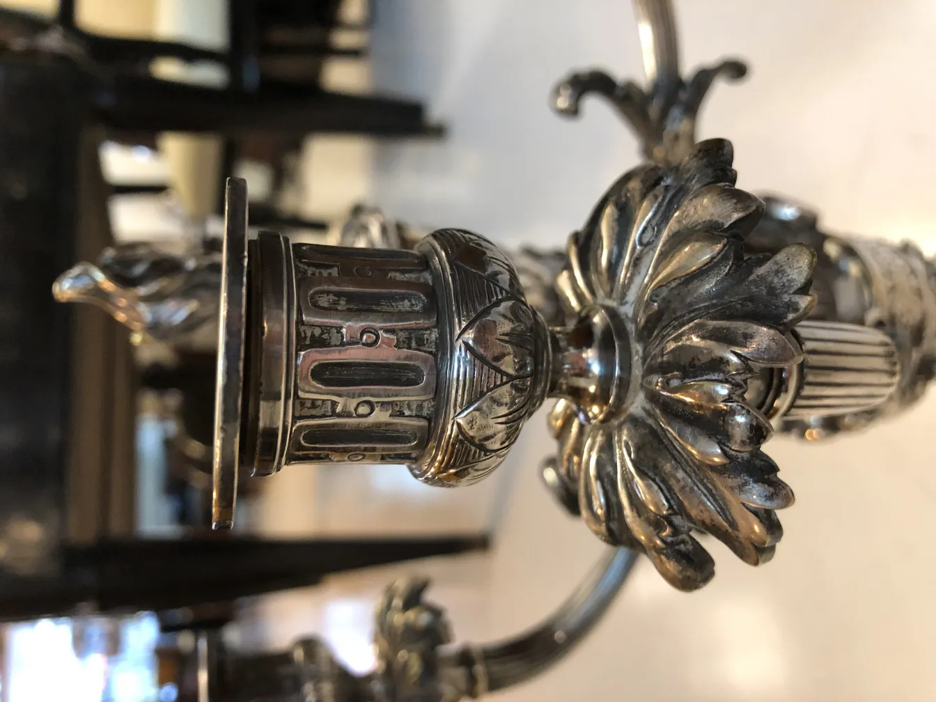 2 antique candelabras with elegant decorative details in the background