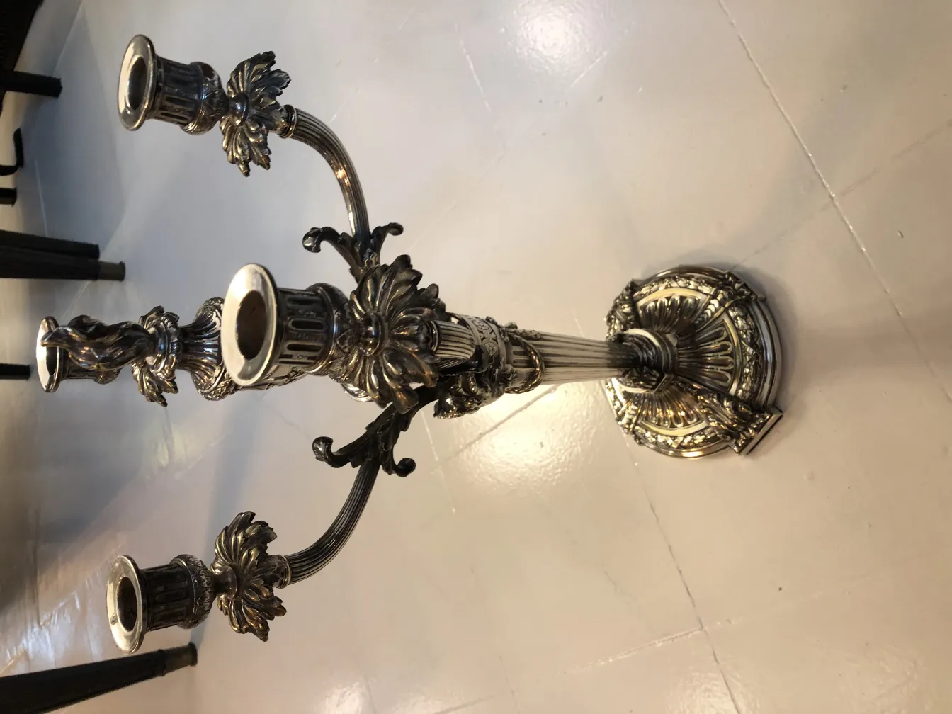 Two antique art nouveau candelabras with intricate details in an elegant setting.