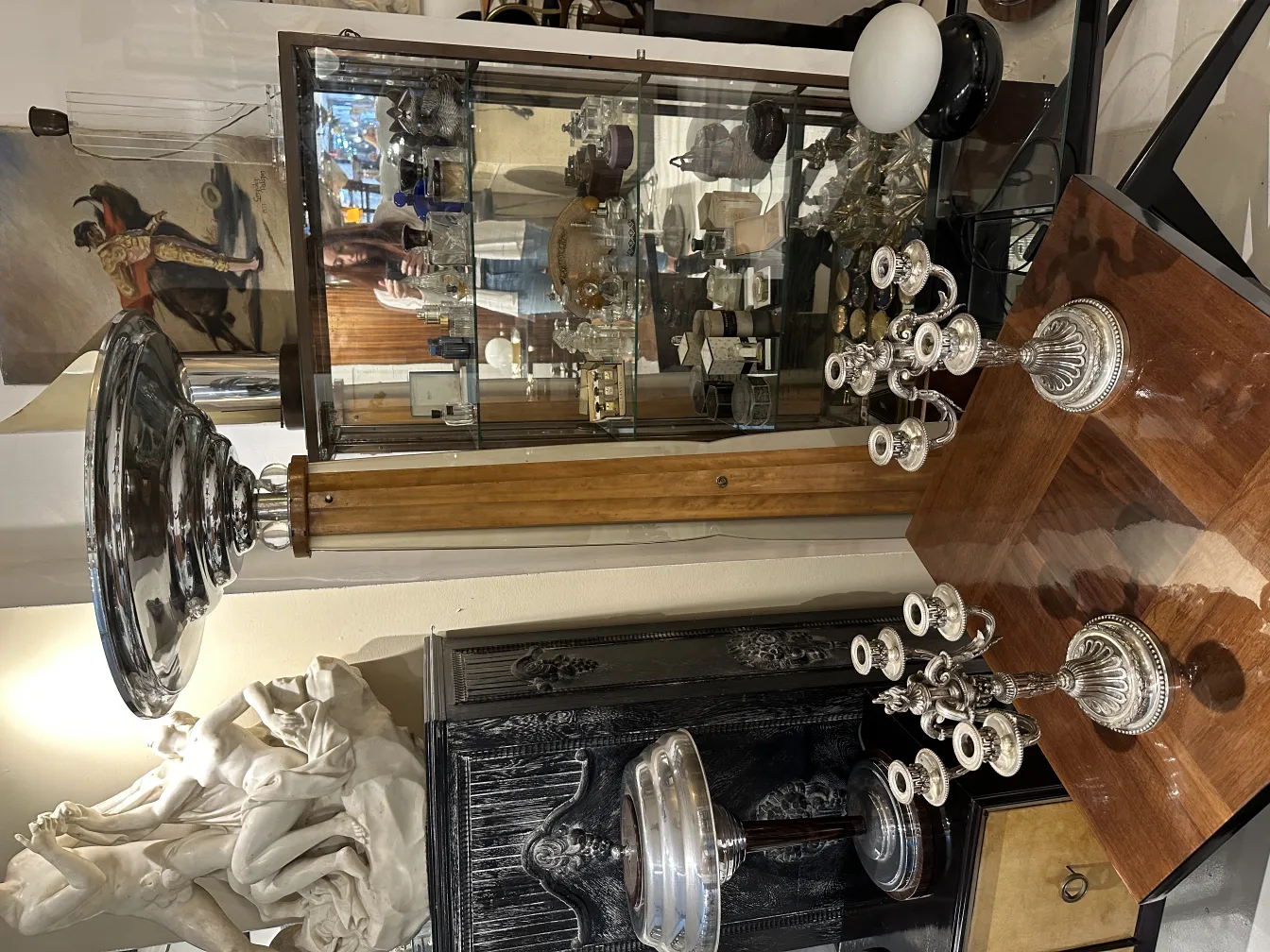 Two antique candelabras in an elegant setting with decorative details and a variety of antique items.