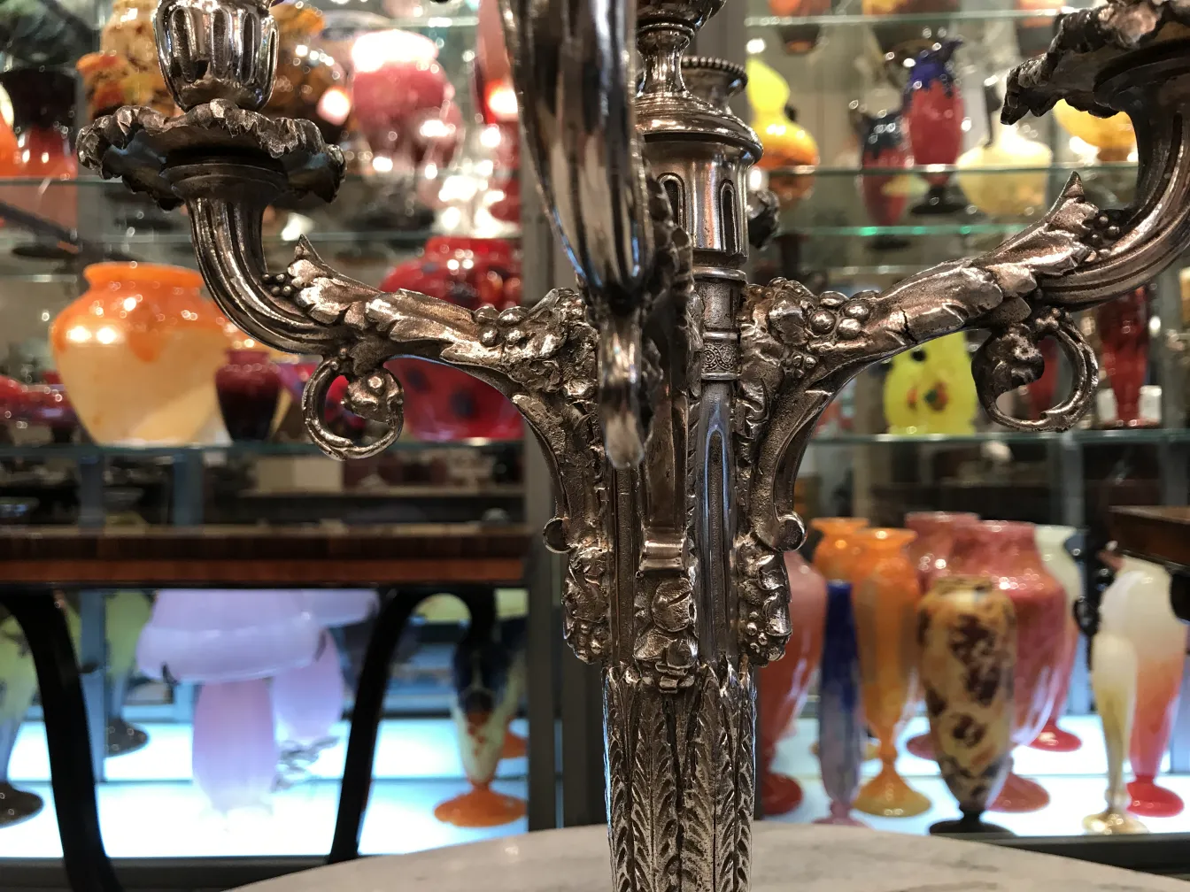 Antique candelabras with intricate detailing in a diverse antique setting.