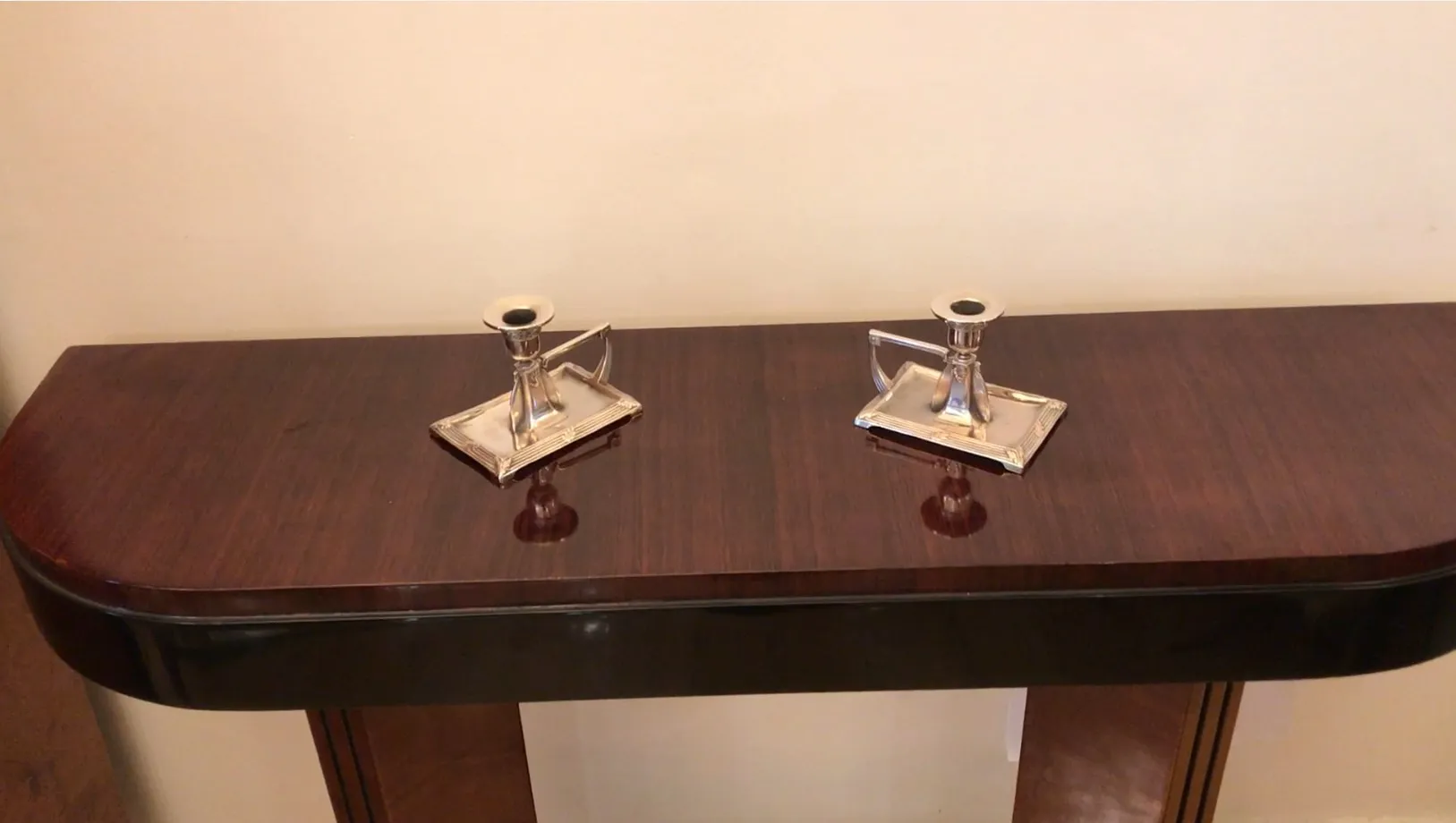 Antique candle holders with a distinctive elegant design on a wooden table.