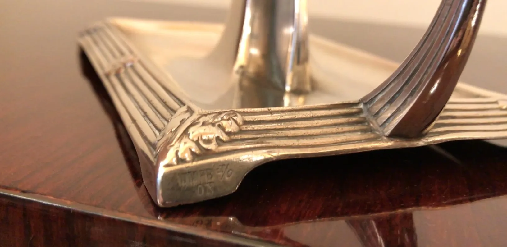 View of 2 antique candelabras with detailed ornaments, dark background.