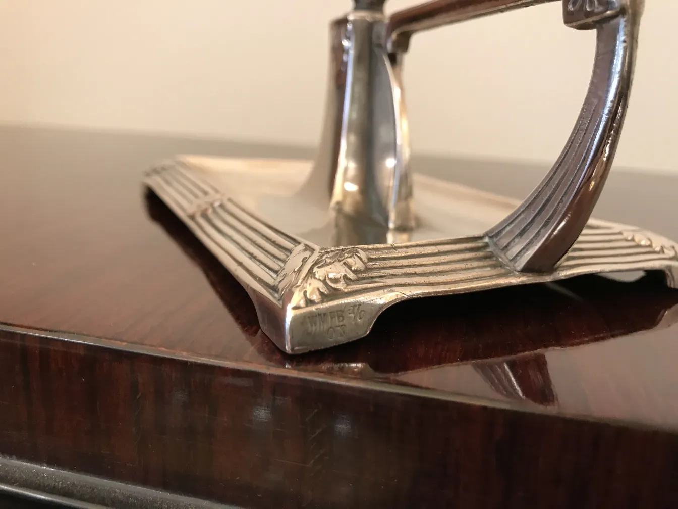 Two antique art nouveau candelabras on a dark wooden surface