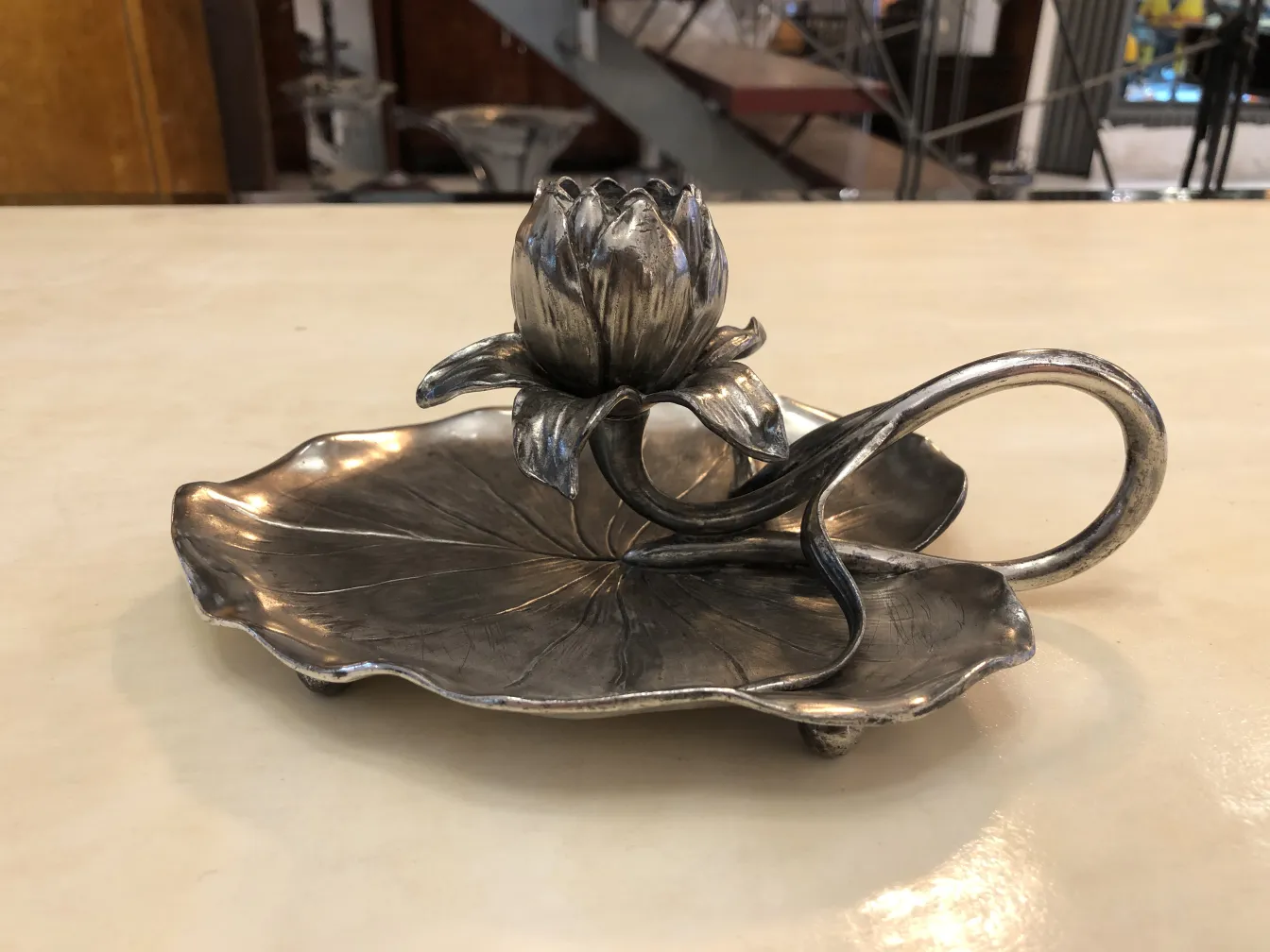 Antique candelabra with leaf-shaped base and lotus flower, shiny metal