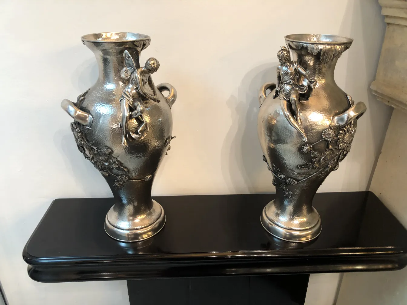two antique vases with art nouveau details on a shelf