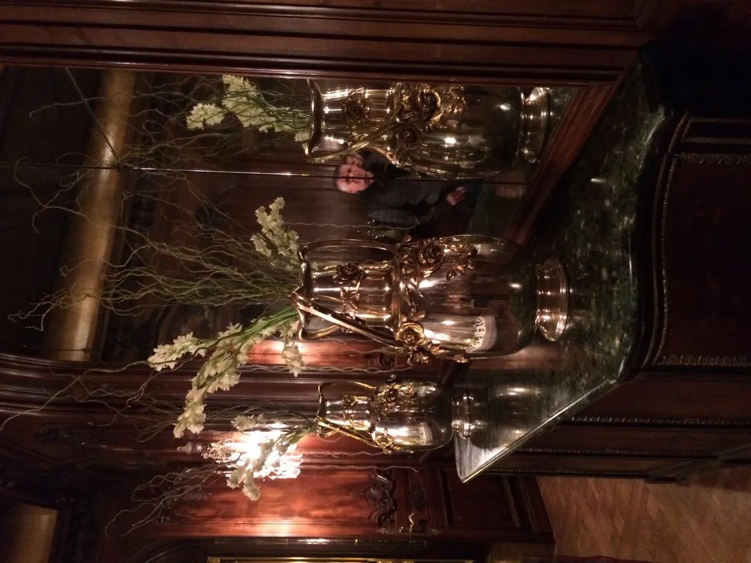 2 antique vases with flowers in an elegant setting.