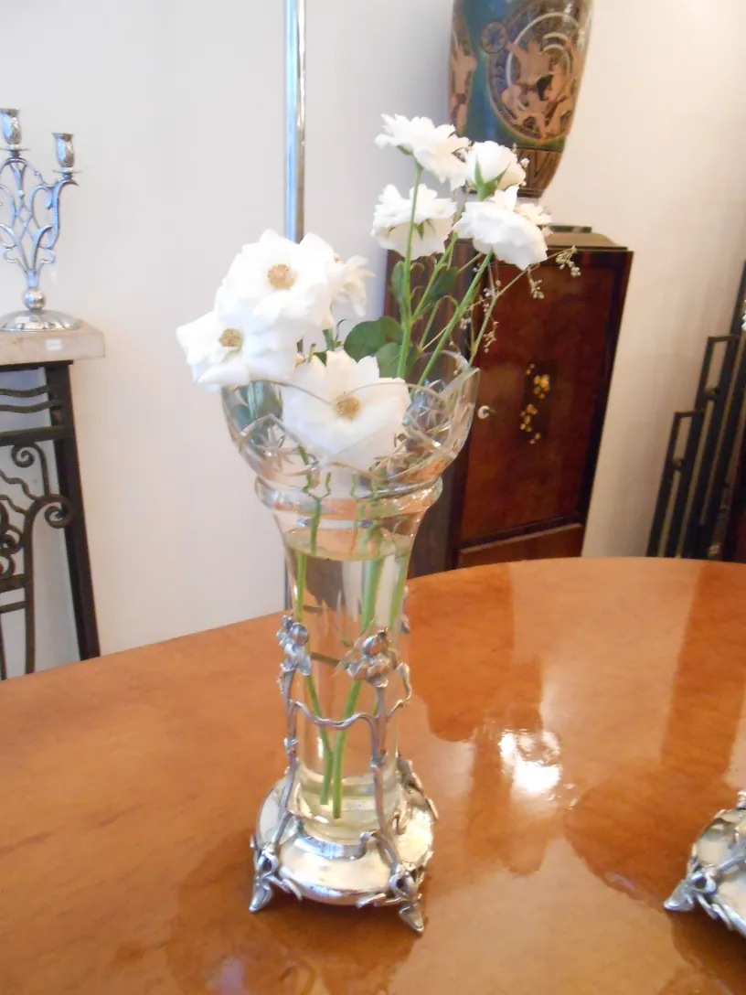 Antique art nouveau vase with white flowers in water.