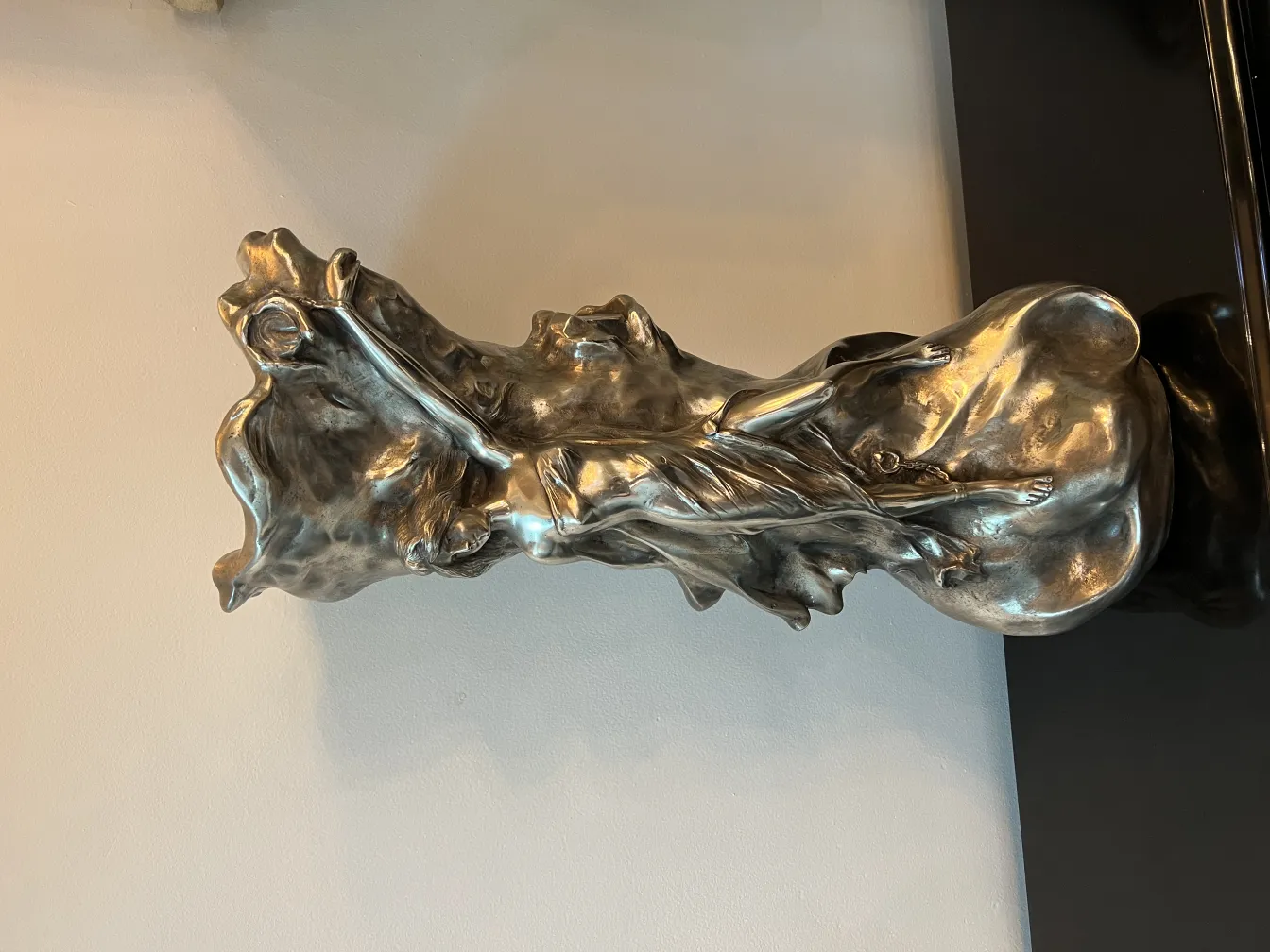 antique vase with shiny organic shape against light wall