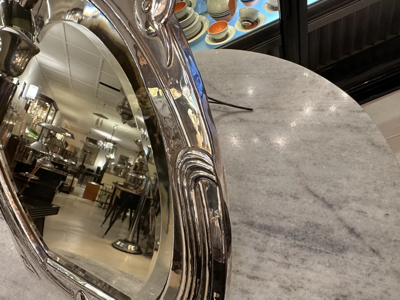 Antique Art Nouveau mirror with decorative details, reflecting the room. Vintage environment with furniture.