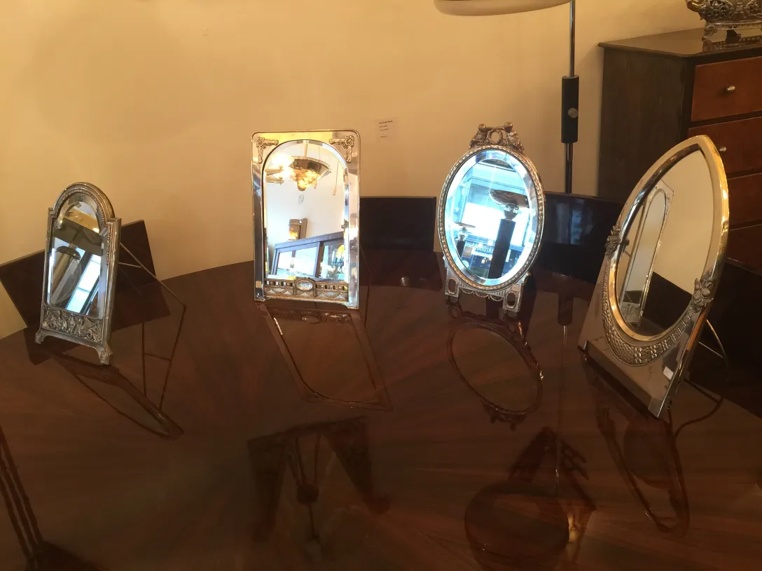 various antique mirrors of different styles on a shiny table