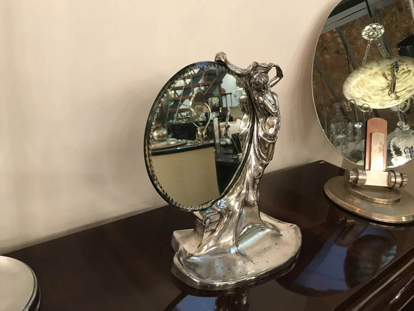 antique mirror with decorative Art Nouveau base in background