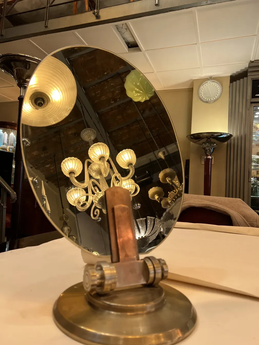 Antique mirror with stand, well-lit surroundings, Art Nouveau style.