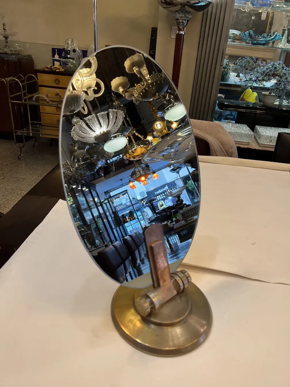 Antique table mirror with Art Nouveau design, oval shape and decorative base, in an elegant setting.