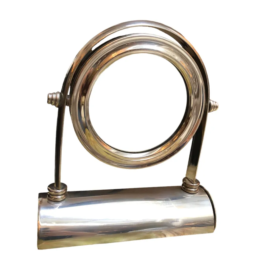 Antique mirror with artistic design in an elegant stand.