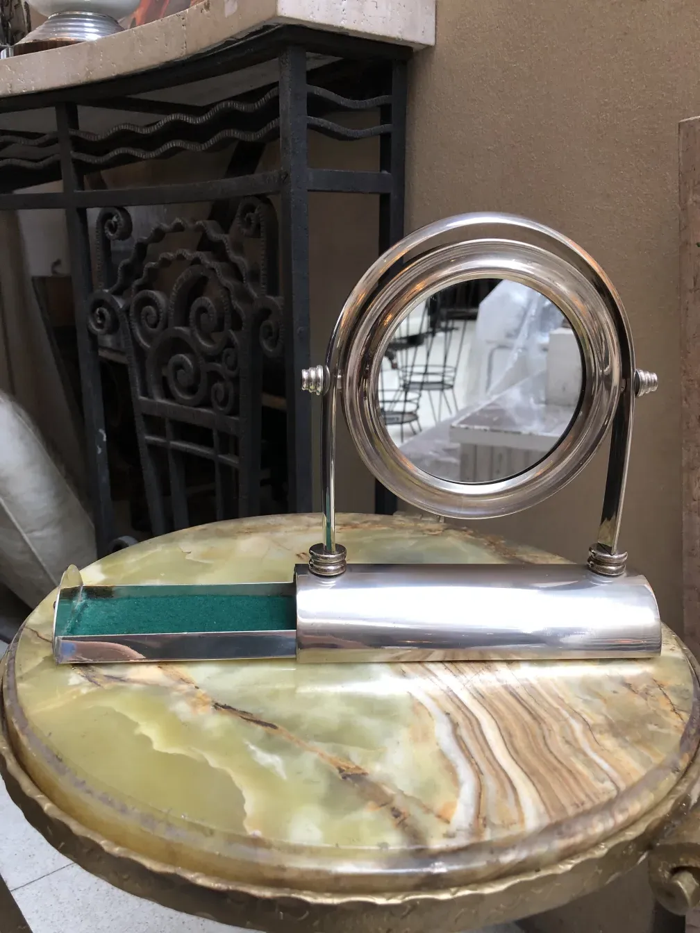 antique mirror with elegant design and artistic base, placed on a decorative surface.
