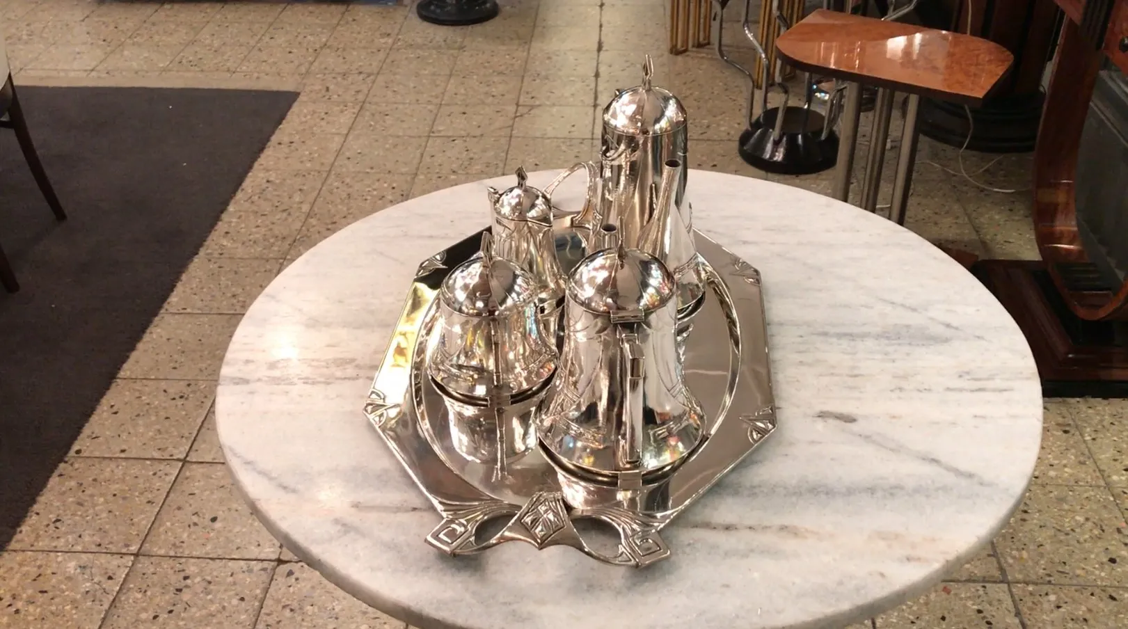 Antique tea set WMF displayed on a marble table.
