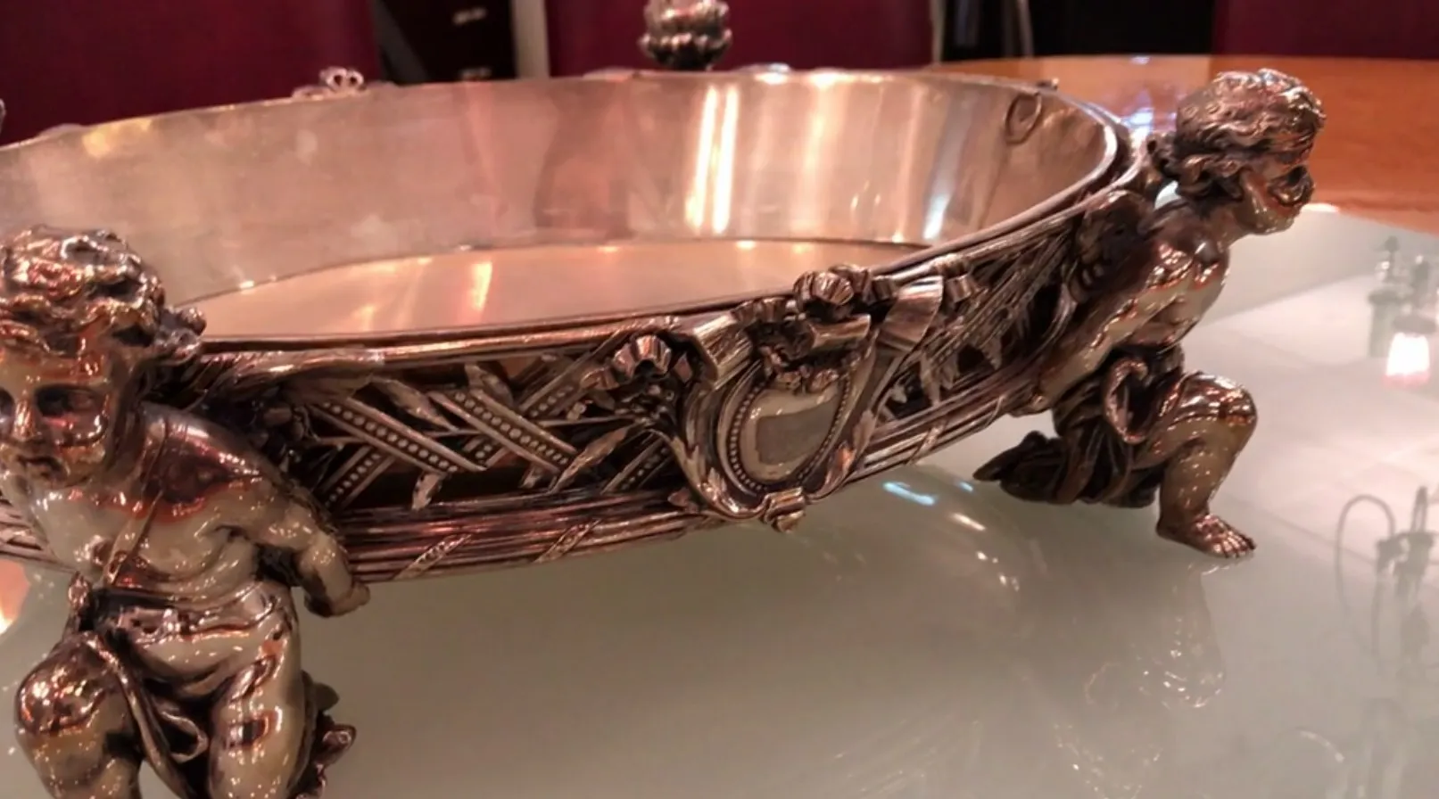 antique centerpiece with decorative figures on the sides
