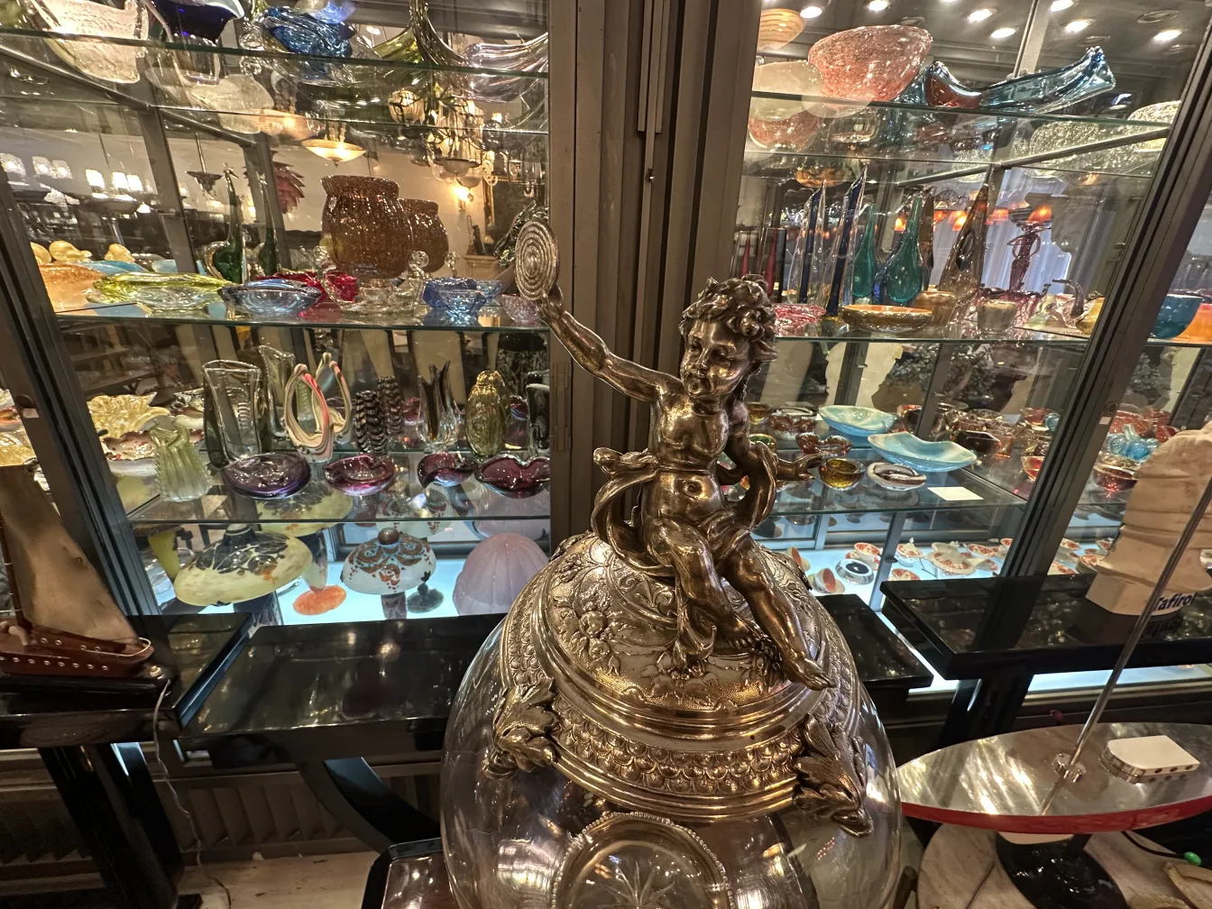 Antique WMF centerpiece with a child figure on a globe, surrounded by decorative items
