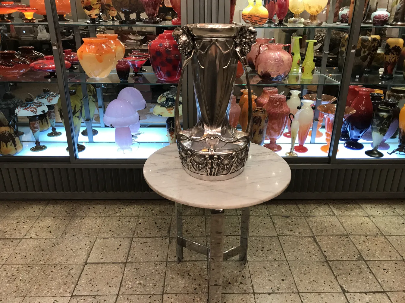Antique WMF champagne coolers displayed among colorful vases.