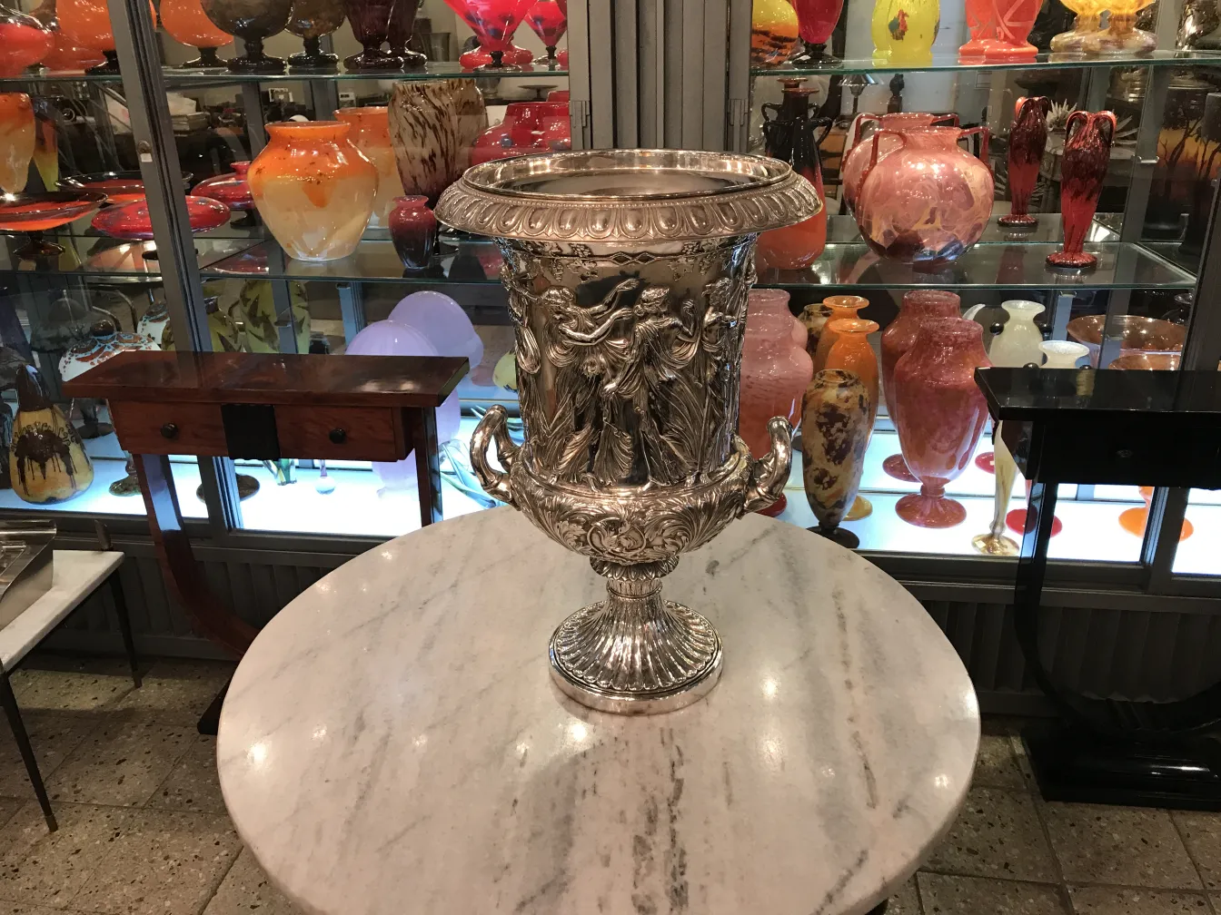 two antique champagne coolers wmif on a table surrounded by colorful vases