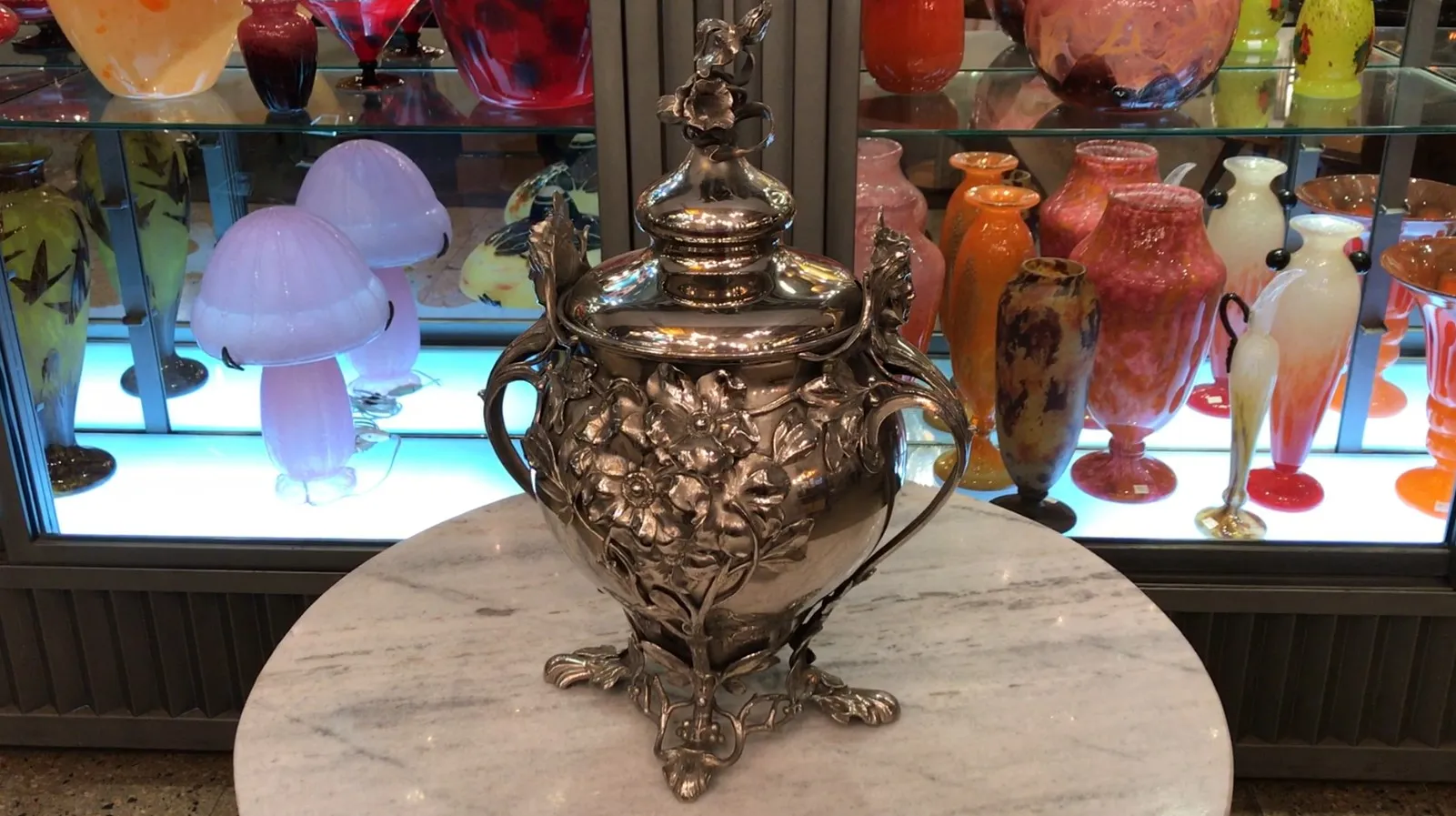 antique WMF punch bowl with floral decoration and colorful vases in background