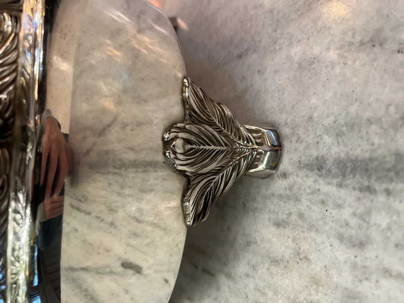 Antique WMF punch bowl with floral edge details, reflecting light