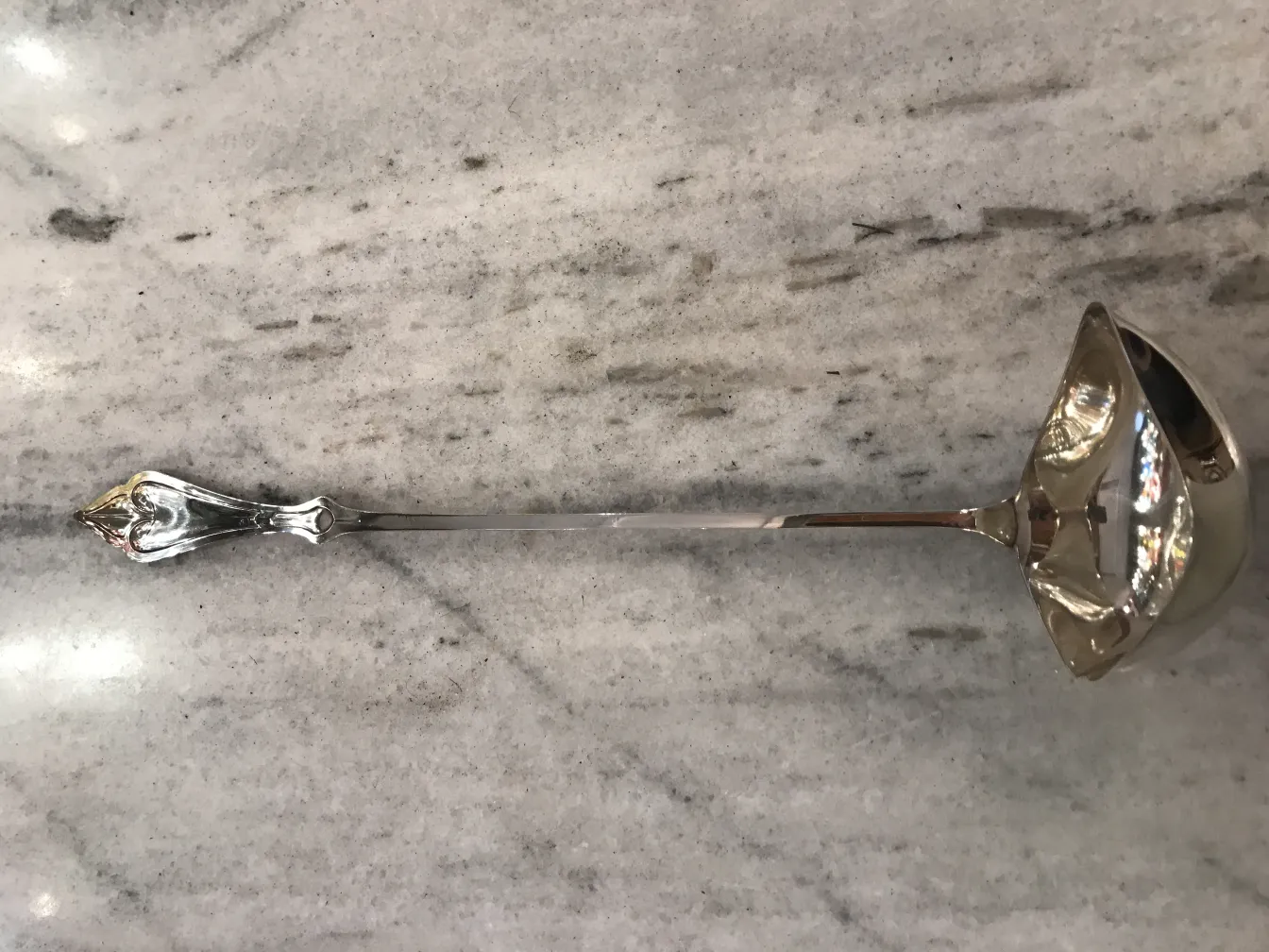 Antique WMF punch bowl with elegantly designed ladle on a clear surface.