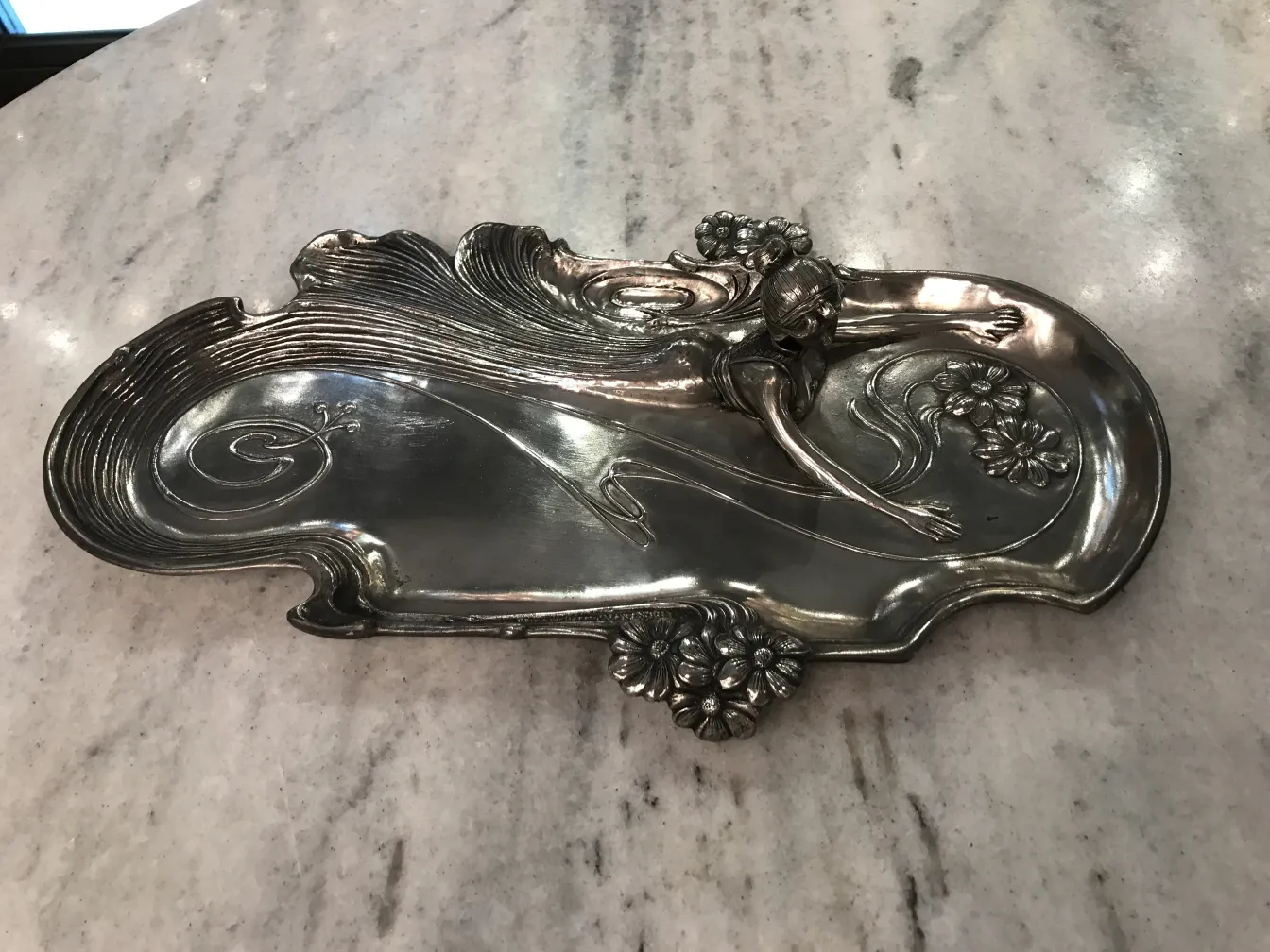 Antique WMF card tray with floral relief design.