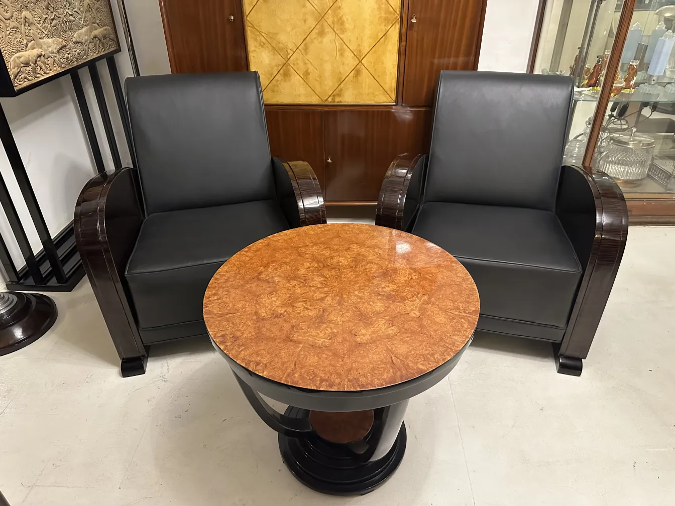 Pair of antique armchairs with black upholstery and a round table