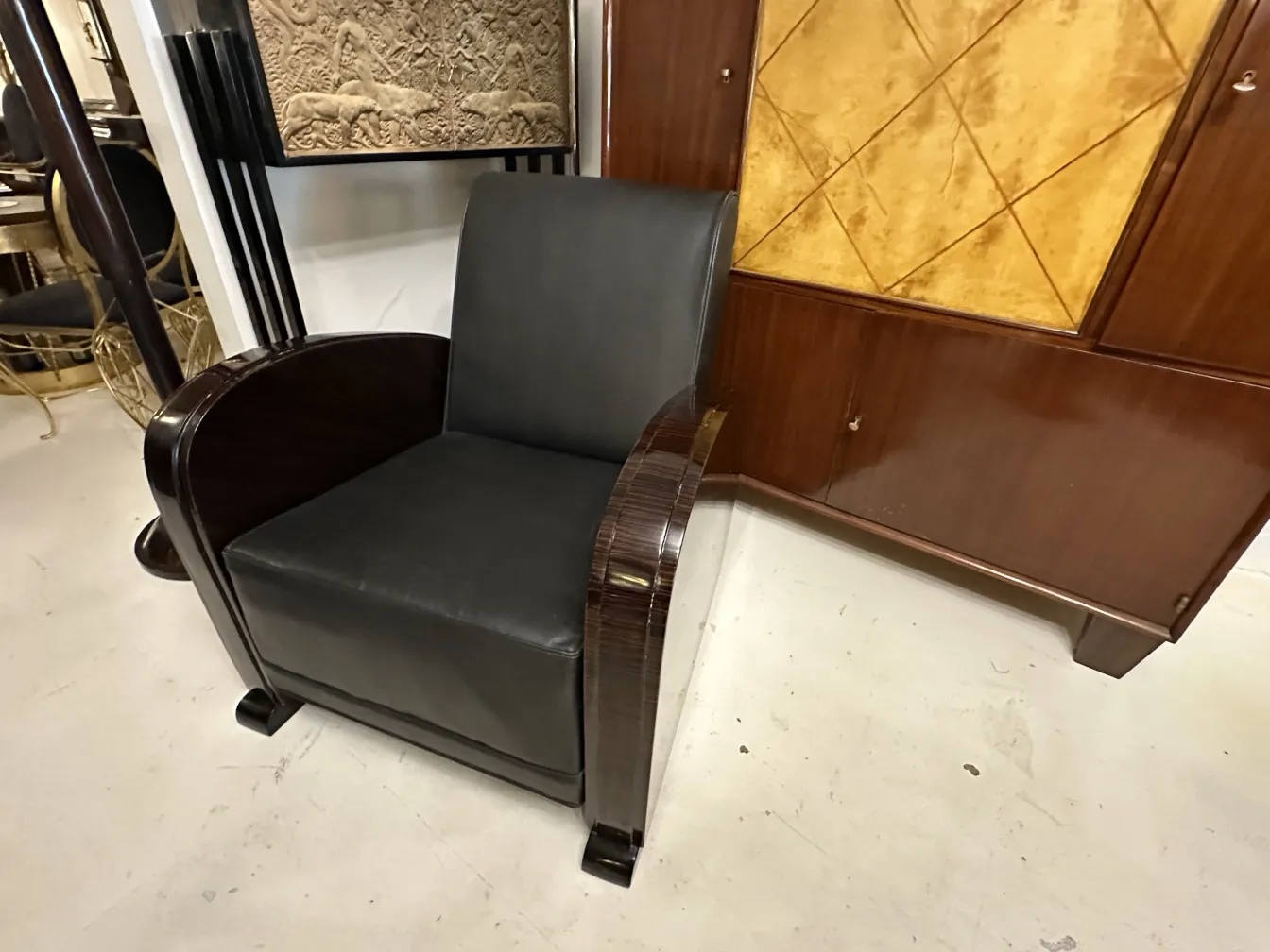 side view of 2 antique armchairs with elegant arms in a neutral setting