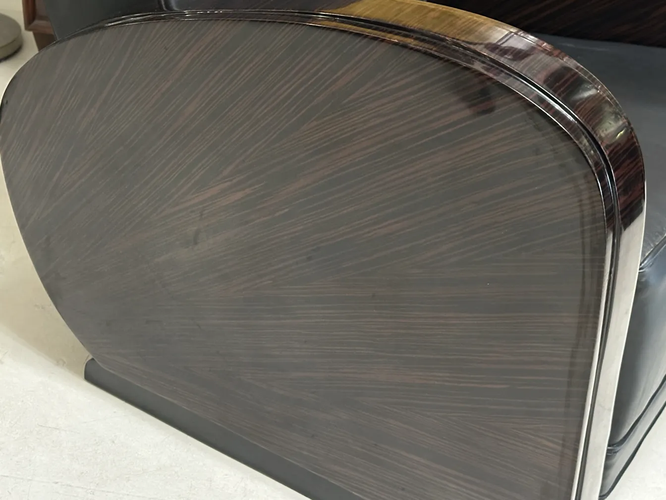 Side view of 2 antique armchairs with elegant design and dark colors.