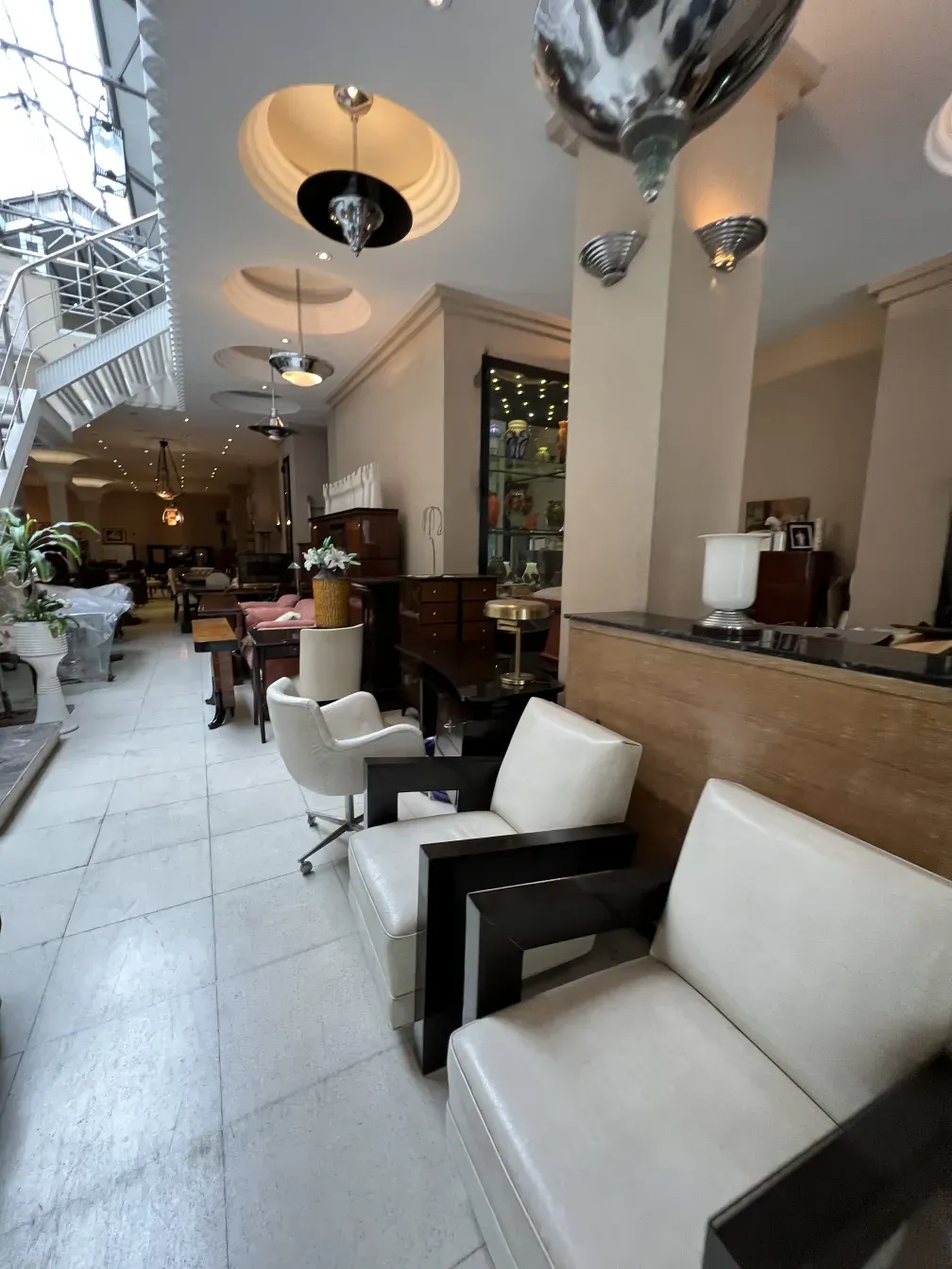 View of 2 antique armchairs in an elegant setting with decor.