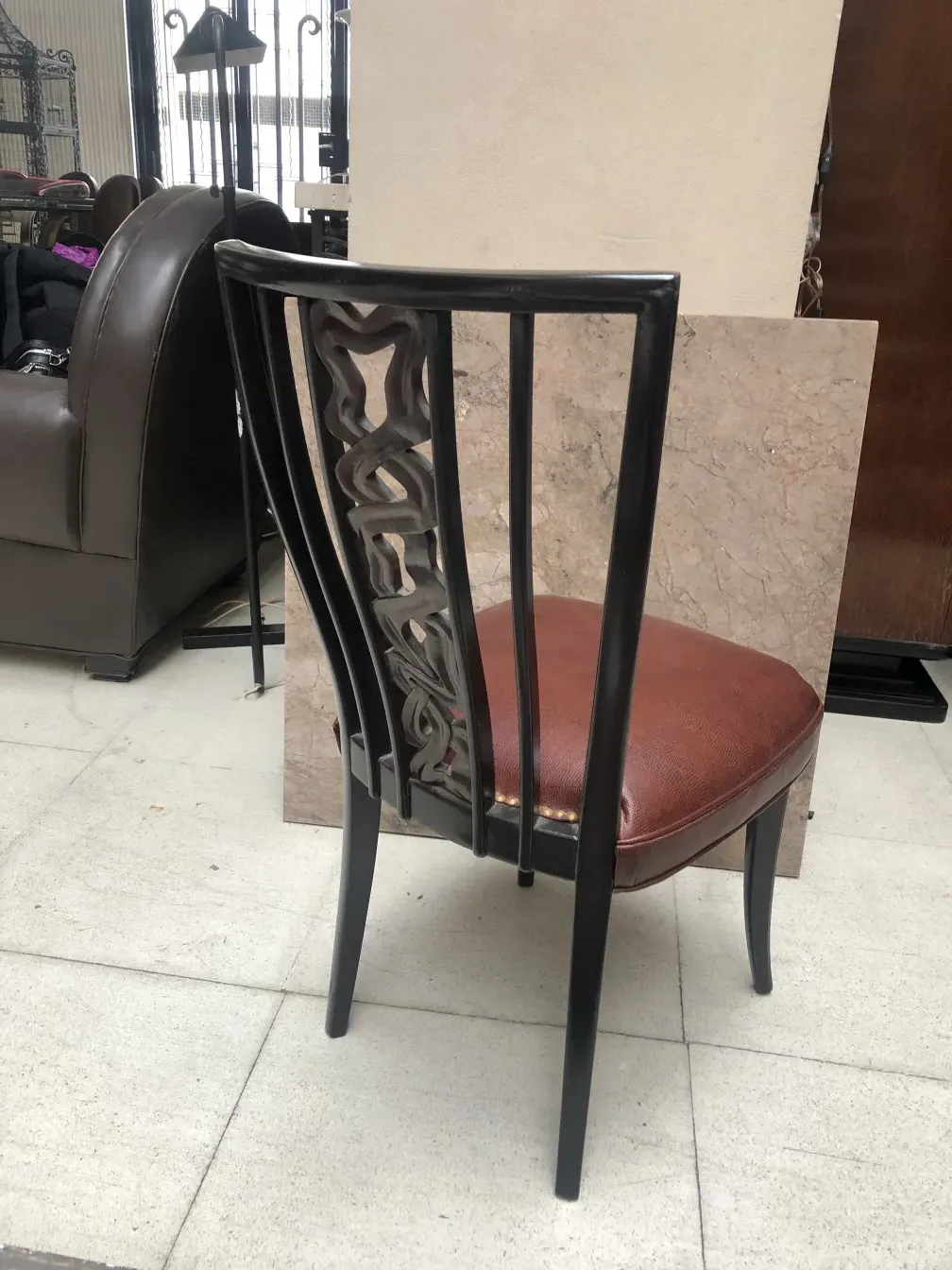 两把古董椅子背部有建筑设计，阳光明媚的环境中