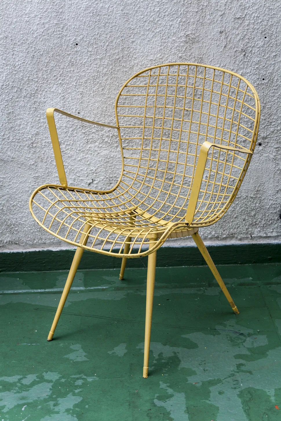 Antique garden armchair with yellow grid design in an outdoor setting.