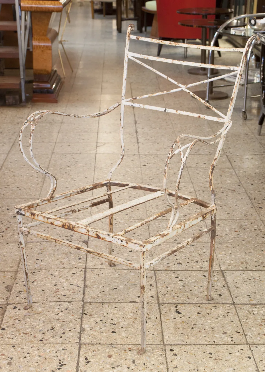 Antique garden armchair with visible structure in a spacious setting.