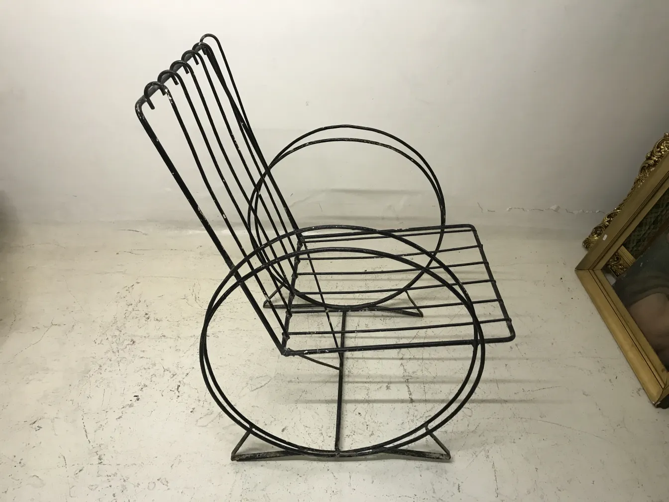 two antique garden armchairs with elegant lines and circular shape, in a neutral setting