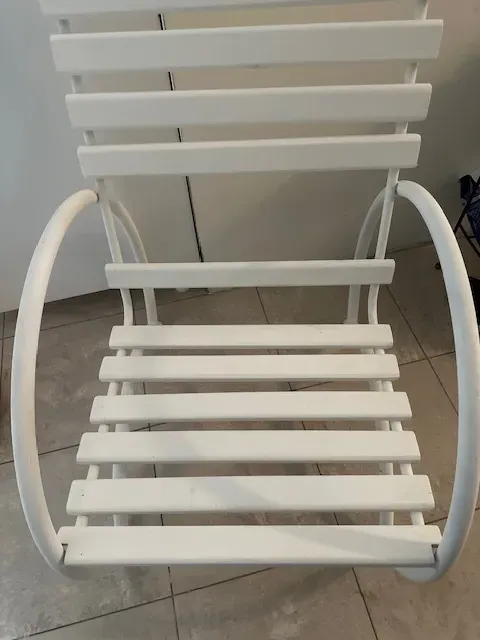 Two antique garden armchairs in white color in a modern setting.